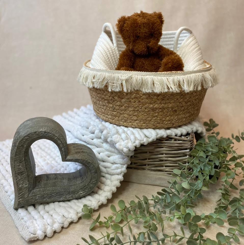 A bear in a basket next to a stone heart - Willow Tree Reborns